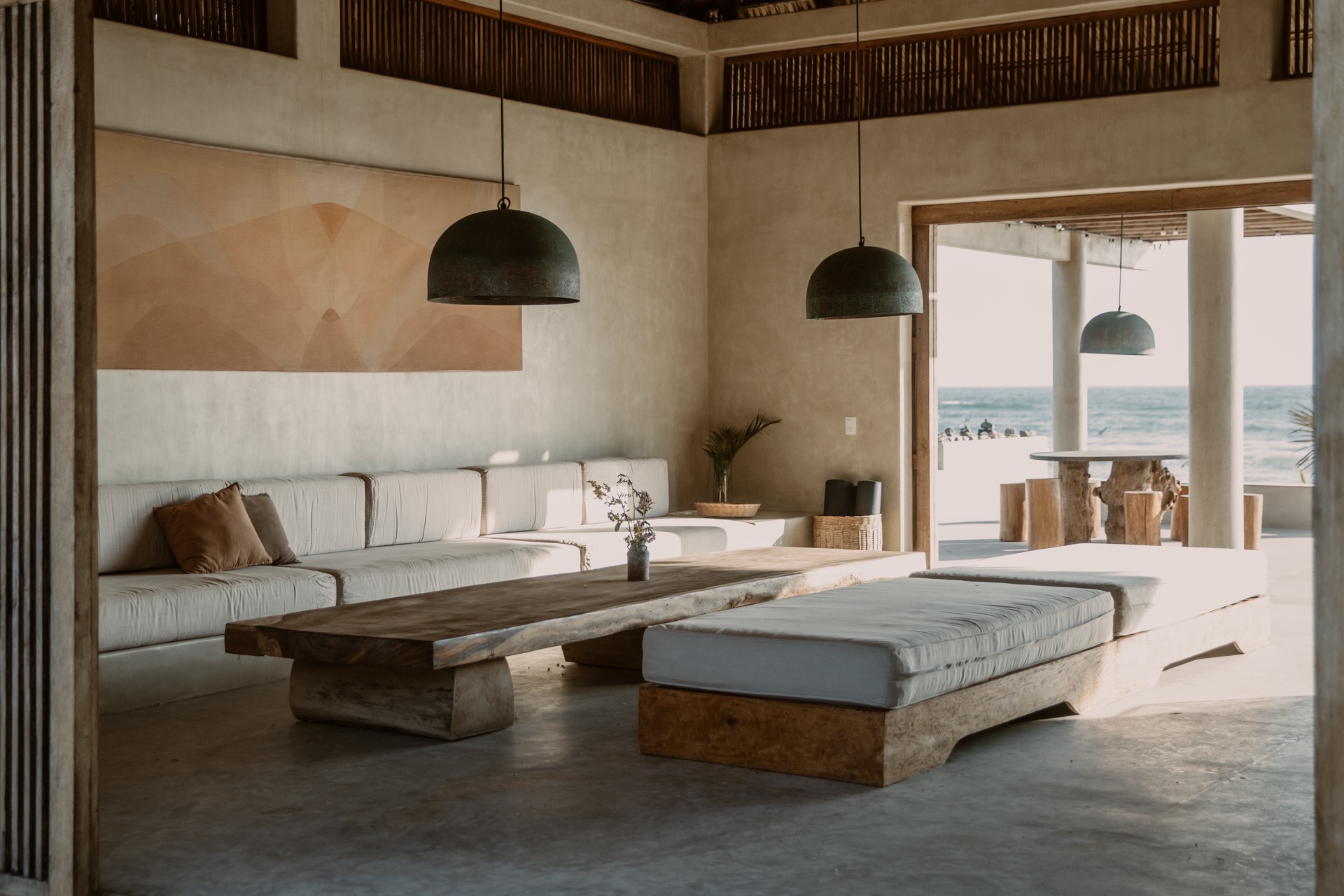Living room with pendant lights, built-in sofa and ocean view