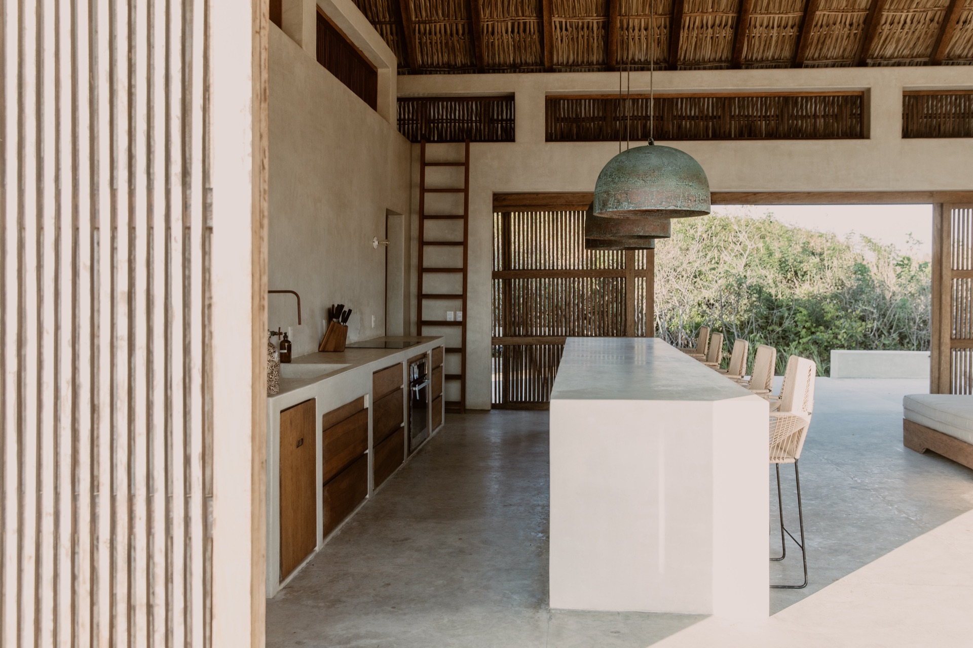 Palapa kitchen with island, pendant lights and loft ladder