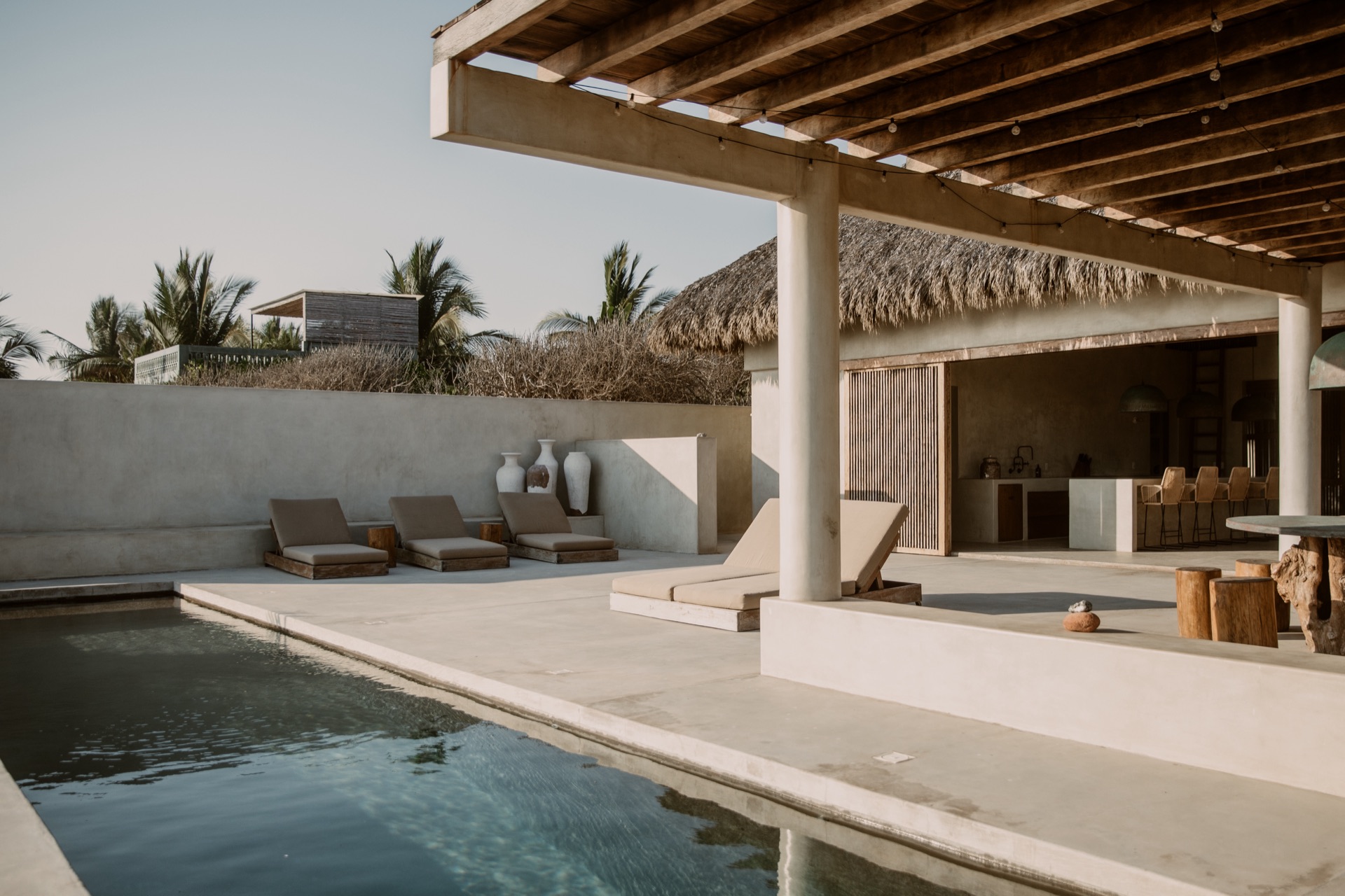 Pool deck with loungers and palapa architecture