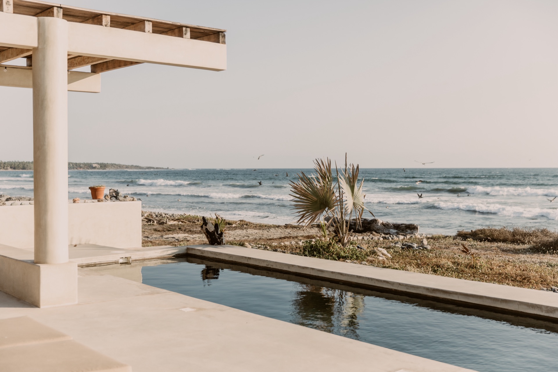 Pool edge with La Saladita surf breaking behind
